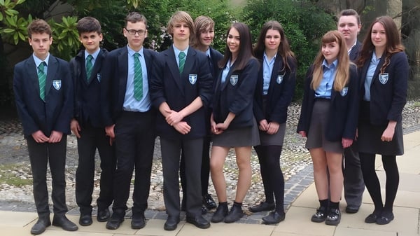 Un grupo de estudiantes está en el jardín en el terreno de la Seaford Head School.