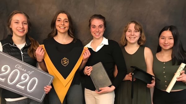 Cinco estudiantes de la Selkirk Secondary School están juntas y sostienen un cartel con la inscripción Clase de 2020.