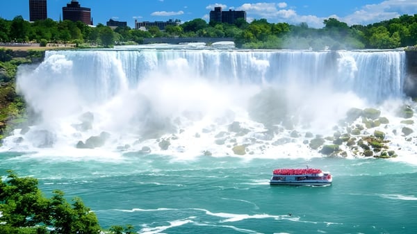 Un bote rojo con pasajeros navega frente a una cascada cerca de la Seycove Secondary School.