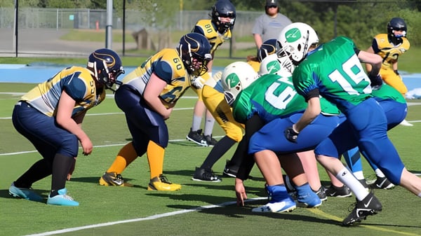 Un grupo de jugadores de fútbol está disputando un partido en el campo de deportes de la Shas Ti Kelly Road Secondary School.