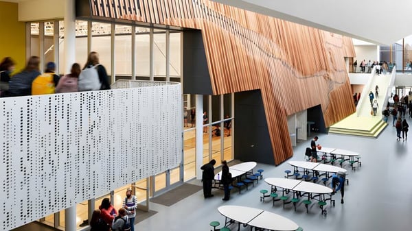 Moderno interior con pared de madera y filas de asientos en el campus de la Shas Ti Kelly Road Secondary School.