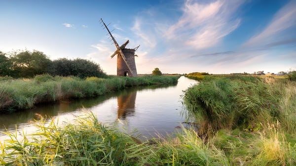 Un pintoresco molino de viento se encuentra junto a un canal tranquilo en el terreno de la Shrewsbury School.