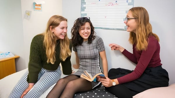 Tres estudiantes de la Sibford School están sentadas en el aula y mantienen una conversación.