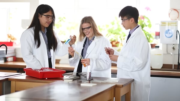 Tres estudiantes de la Sidcot School trabajan juntos en un laboratorio con equipos científicos.