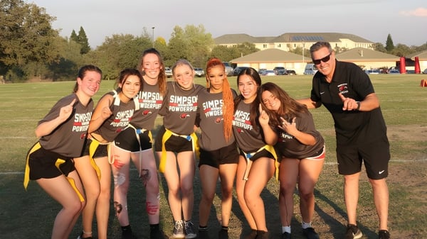 Un grupo de jóvenes deportistas posan juntas en un campo de césped en el campus de la Simpson University.