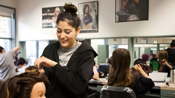 Una estudiante de la Sir Guy Carleton Secondary School peina a una clienta en un salón de belleza.