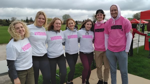 Un grupo de estudiantes de la Sir Wilfrid Laurier Secondary School está en un prado frente a edificios.