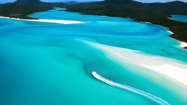 Una toma aérea de una laguna turquesa rodeada de colinas verdes cerca del Solway College.