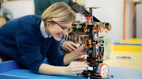 Una estudiante de la South Carleton High School se concentra en la reparación de un dispositivo mecánico en el taller.