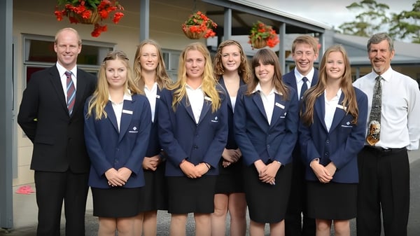 Un grupo de estudiantes de la Springbank School está junto a un edificio con decoración festiva.