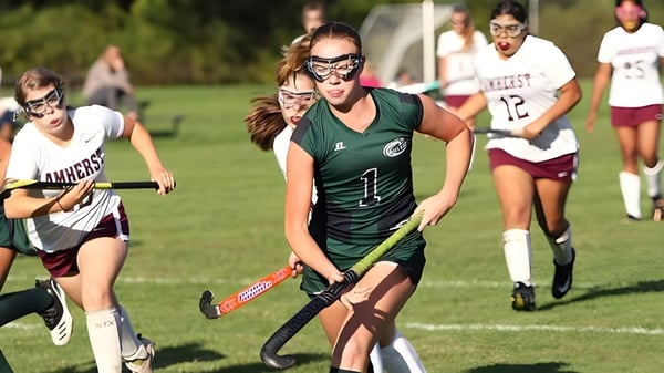 Alumnas de St. Angela’s College juegan un partido de hockey sobre césped en el campo deportivo.