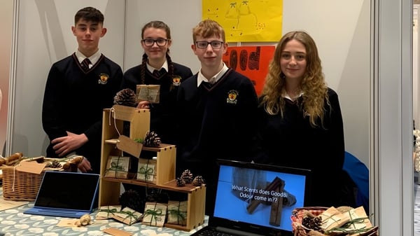 Estudiantes del St. Bricin’s College están frente a una exhibición con una laptop y cestas.