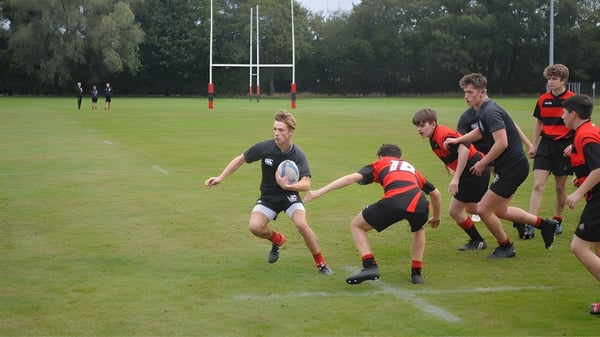 Un grupo de estudiantes juega al rugby en el campo deportivo de la St. Christopher School.