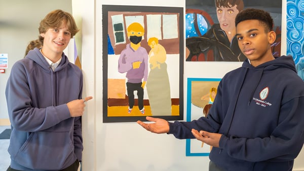 Dos estudiantes del St. Columba's College están frente a una colorida pintura en la pared.