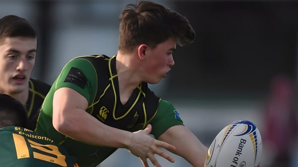 Un estudiante de St. Conleths College sostiene un balón de rugby en el campo deportivo.