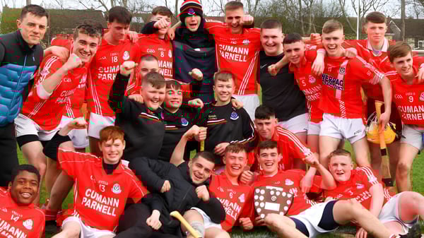 Un grupo de estudiantes en uniformes rojos celebra al aire libre en el terreno de St. David's C.B.S.
