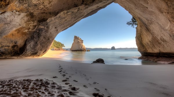 Vista de un paisaje de playa con un arco rocoso y el océano al fondo cerca de St. Dominic's Girl’s Catholic College.