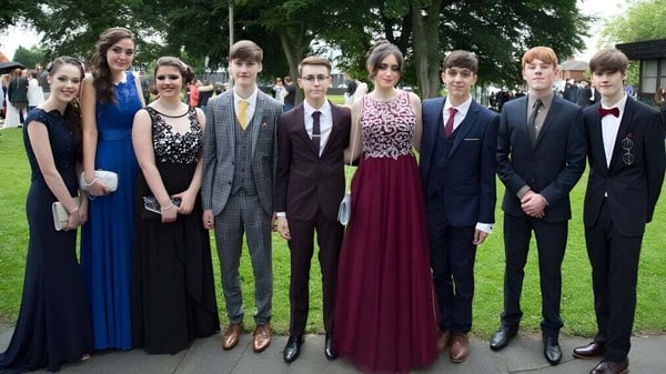 Un grupo de alumnos de St. Edmund’s College está junto en un área parecida a un parque con árboles al fondo.