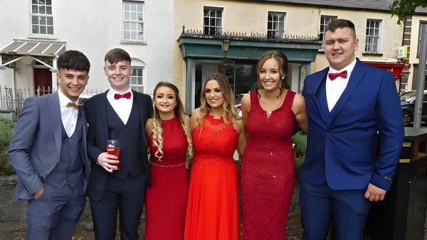 Un grupo de cinco estudiantes está de pie frente a un edificio en el campus de St. Fergal’s College.