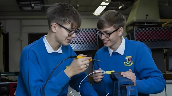 Dos estudiantes de St. Finian’s Community College investigan juntos algo en un laboratorio.