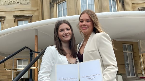 Dos estudiantes sonríen frente a un edificio histórico en el campus de St. Francis' College.