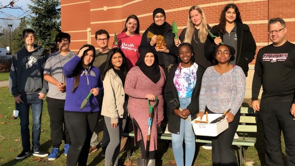 Un grupo de estudiantes está frente a un edificio de ladrillo en el terreno de la St. Francis Xavier High School.