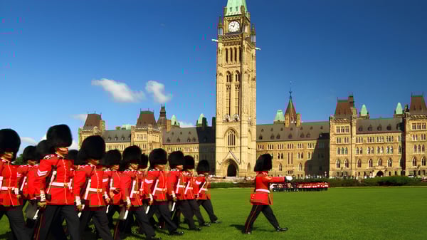 Un grupo de guardias reales británicos marcha frente a la colina del parlamento en el terreno de la St. Francis Xavier High School.