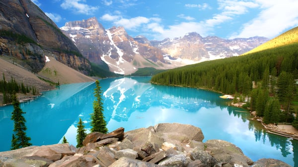Un lago alpino con agua turquesa y montañas cubiertas de nieve al fondo muestra el paisaje natural cerca de St. George’s School.
