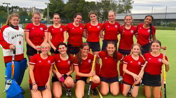 Un grupo de jóvenes atletas en camisetas rojas está en el campo deportivo de la St. George's School en Edimburgo.