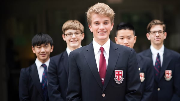 Un grupo de estudiantes de St. George’s School está de pie juntos en un entorno formal.