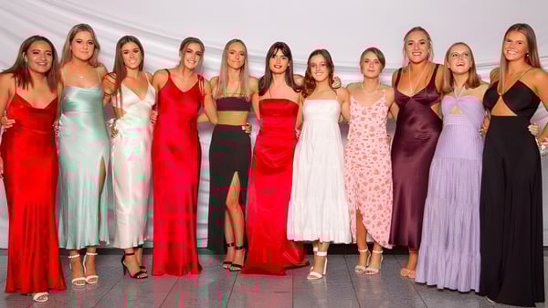 Un grupo de jóvenes mujeres posan juntas frente a un fondo blanco en el campus de St. Hilda's Collegiate School.