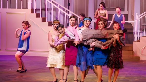 Estudiantes de la St. John's School realizan una animada actuación en una escalera.