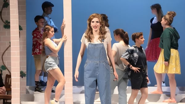 Un grupo de estudiantes de la St. Johnsbury Academy está frente a un fondo azul.
