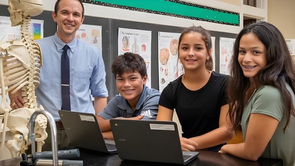 Estudiantes y un docente de la St. Joseph High School trabajan juntos en un portátil en el aula con modelos anatómicos.