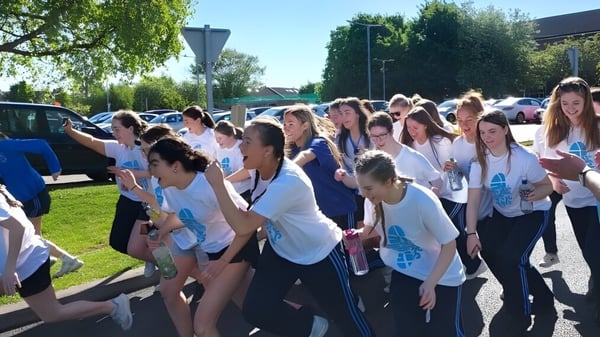 Un grupo de jóvenes está juntos al aire libre en el campus de la St. Joseph of Cluny.