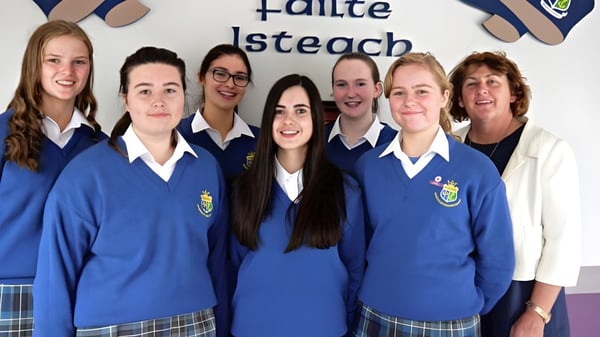 Un grupo de estudiantes y profesores de la St. Joseph’s Secondary School (Castlebar) posan juntos frente a un cartel de bienvenida.