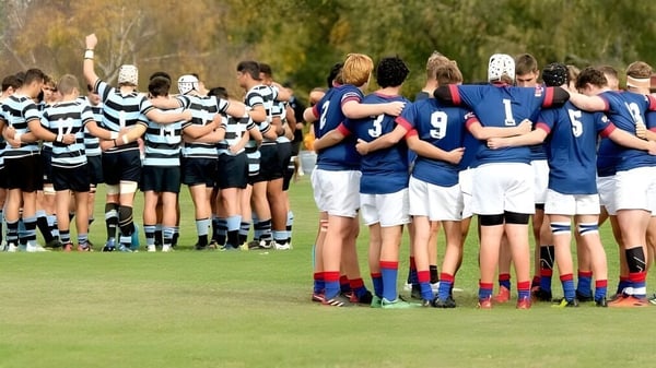 Dos equipos de rugby forman un huddle en el campo de St. Kevin’s College.