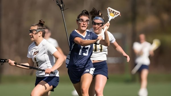 Alumnos de la St. Mark's School juegan lacrosse en un campo deportivo con fondo desenfocado.