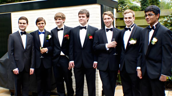 Un grupo de jóvenes hombres en ropa formal está en el área exterior del campus de St. Mary’s College Ballysadare.