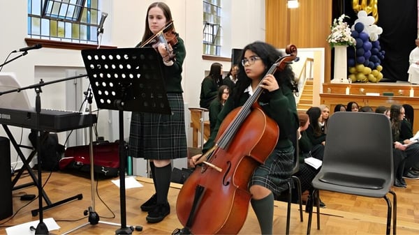 Alumnas de St. Mary's Holy Faith Killester tocan música en el escenario durante un concierto.