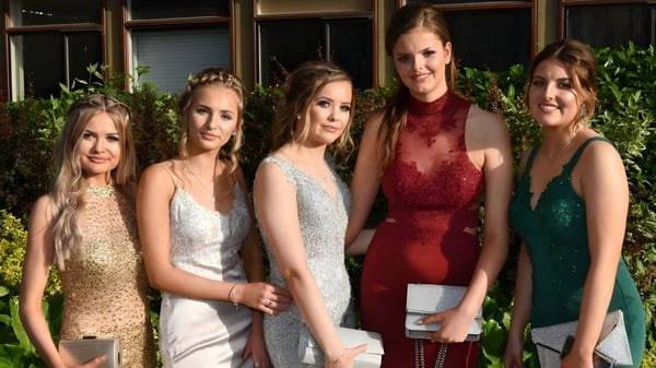 Cinco alumnas de St. Mary's Holy Faith Killester posan frente a un edificio con plantas verdes.