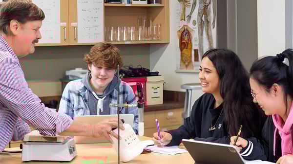 Un grupo de alumnas y alumnos de la St. Mary's School discute con un docente en el aula.