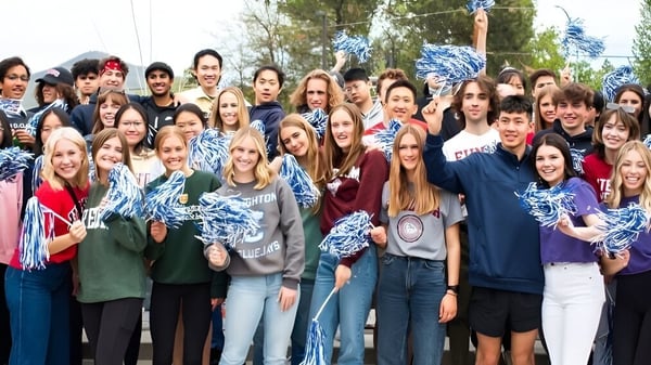 Un gran grupo de alumnas y alumnos de la St. Mary's School se reúne afuera frente a árboles.