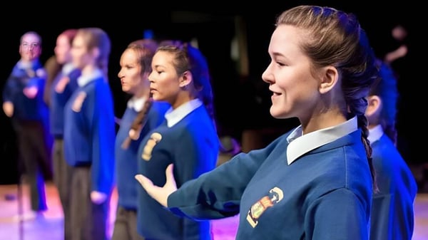 Estudiantes de la St. Mary's Secondary School (Macroom) están juntos en el escenario y realizan una actuación.