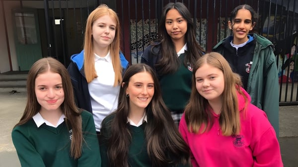 Un grupo de alumnas está frente a un edificio con una puerta de metal en el terreno de la St. Mary's Secondary School en Charleville.
