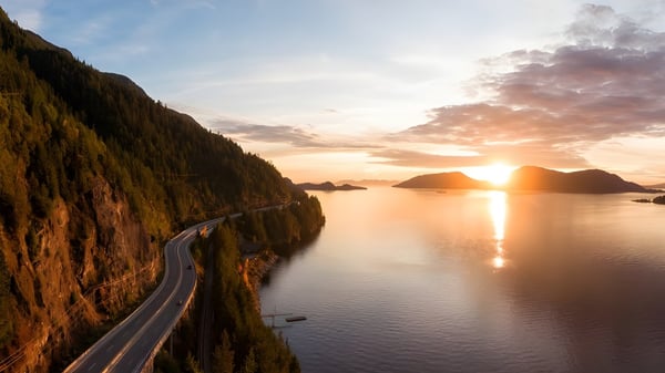 Una carretera costera se extiende a lo largo de acantilados empinados con vista a aguas tranquilas al atardecer cerca de la St. Michaels University School.