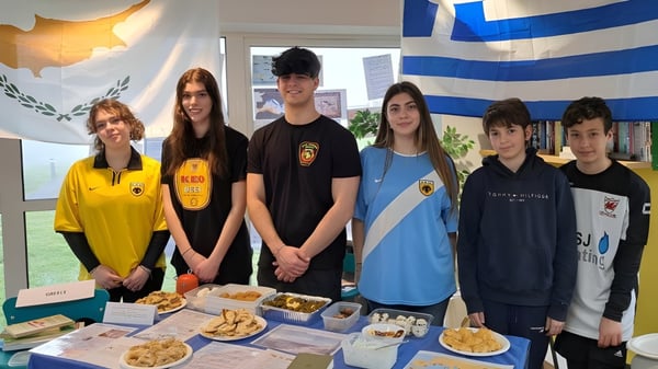 Alumnos de la St. Michael’s School están frente a una exhibición con varios alimentos y colorida decoración.