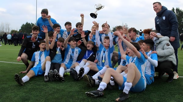 Un grupo de jóvenes futbolistas de St. Muredach's College celebra su victoria en el campo.
