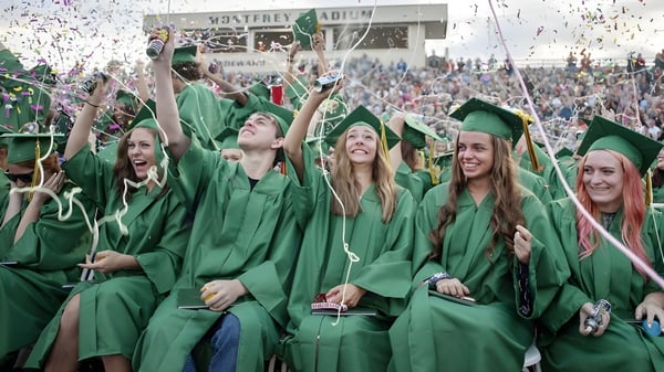 Los graduados de St. Patrick's High School celebran con vestimenta verde y confeti.
