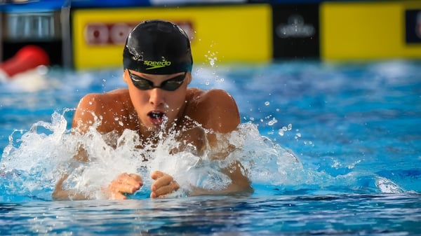 Un nadador con gorra negra y gafas de natación realiza el estilo de pecho en la piscina de St Paul’s School.